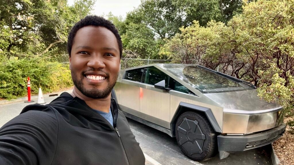 A self portrait of Mandlenkosi Vana standing next to the Tesla Cybertruck at the Tesla headquarters whilst on his mindful travel adventure to the USA